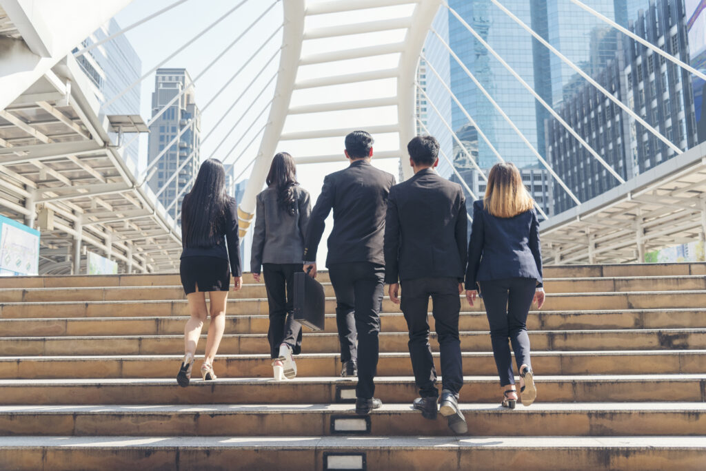 Professionals climbing up the stairs, representing career advancement strategies.